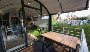 una mesa de comedor en la cubierta de una casa en LokoMotel-Waggon, Luxus Appartment im Eisenbahnwaggon, en Stadtlohn