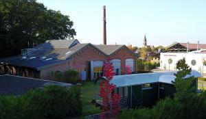 una casa de ladrillo rojo con techo blanco en LokoMotel-Waggon, Luxus Appartment im Eisenbahnwaggon, en Stadtlohn