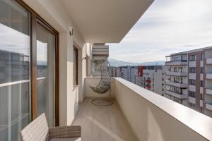 balkon z krzesłem i widokiem na miasto w obiekcie D&C Apartament w Braszowie