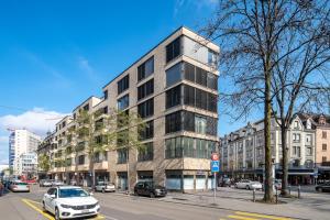 un grand bâtiment dans une rue de la ville avec des voitures dans l'établissement CITY STAY - Franklinstrasse, à Zurich