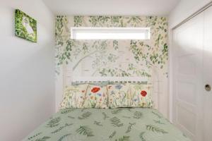 - une chambre avec un lit orné de fleurs sur le mur dans l'établissement Cosy and modern 1 bedroom garden house - very dog friendly!, à Tarves