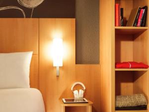 a hotel room with a bed and a shelf with books at ibis Southampton in Southampton