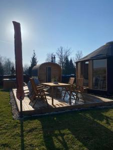 - une terrasse en bois avec une table et des chaises dans la cour dans l'établissement Yary Yurt, à Všeruby