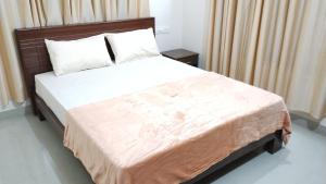 a bedroom with a large bed with white sheets at Eve's appartment in Meppādi