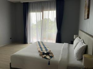 um quarto com uma grande cama branca e uma janela em Aonang Inn em Cidade de Krabi