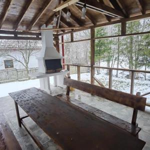 een veranda met een fornuis en een houten bank bij Rustic House Busteni in Buşteni