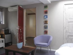 Sala de estar con silla morada y mesa en Bed & Office 050, en Groninga