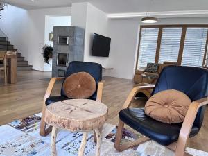 uma sala de estar com duas cadeiras e uma mesa em Chalet Deer Trail Tatranská Lomnica em Tatranská Lomnica