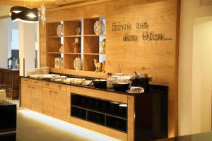 una cocina con paredes de madera y una barra con platos en Hotel Alphof Alpbach, en Alpbach