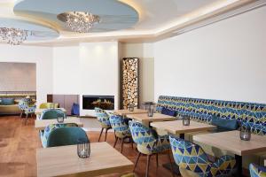 un restaurant avec des tables en bois et des chaises bleues dans l'établissement Sporthotel Zum Hohen Eimberg, à Willingen