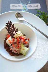 une assiette blanche avec un dessert sur une table dans l'établissement Sporthotel Zum Hohen Eimberg, à Willingen