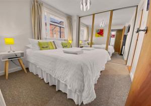 1 dormitorio con 2 camas y espejo en Waterfront Quay, en Gosport