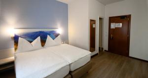 Un pat sau paturi într-o cameră la Acquarello Swiss Quality Hotel