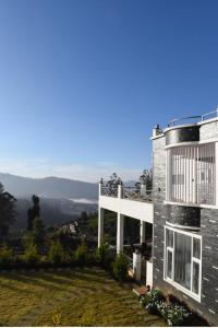 una casa en la cima de una colina con vistas en Orchard Valley View Home Stay, en Ooty