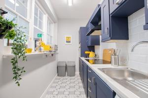 una cucina con armadi blu e lavandino di The Yellow Door by Shortstays a Dublino