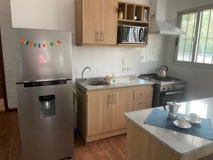 a kitchen with a stainless steel refrigerator and a stove at Magnolio in Colonia del Sacramento