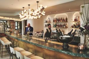 Dois homens num bar num restaurante. em Small Luxury Hotel Ambassador Zurich em Zurique