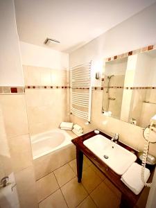 a white bathroom with a tub and a sink at Hotel zur Römerbrücke in Neuwied