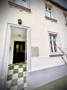 a white building with a door and a checkered floor at Hotel zur Römerbrücke in Neuwied