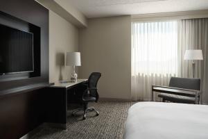 um quarto de hotel com uma cama, uma secretária e uma televisão em Pittsburgh Marriott North em Cranberry Township