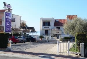 un parcheggio con auto parcheggiate di fronte a un edificio di Villa Amigo a Podstrana