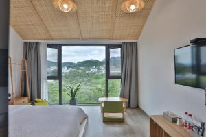 a bedroom with a bed and a large window at Heaven's Gate Home Stay in Zhangjiajie