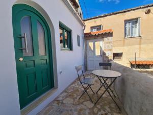 una porta verde e un tavolo con sedie sul portico di Gythio townhouse a Gythio