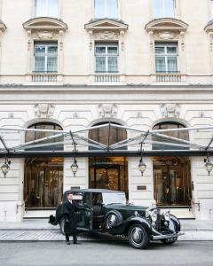 an old car parked in front of a building at The Peninsula Paris in Paris