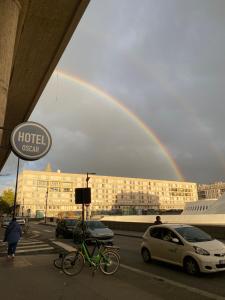 um arco-íris no céu sobre um edifício com uma bicicleta em Oscar Hôtel Le Havre Centre em Le Havre