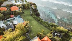 - une vue aérienne sur un complexe avec une piscine et l'océan dans l'établissement Uluwatu Cottages, à Uluwatu