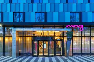 un gran edificio de cristal con un signo msx en él en Moxy Katowice Airport, en Pyrzowice