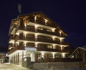 ein hohes Gebäude mit Lichtern in der Nacht in der Unterkunft The Capra Saas-Fee in Saas-Fee