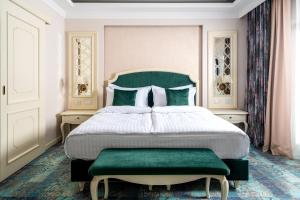 a bedroom with a large bed with a green headboard at Hotel Leul de Aur in Sebeş