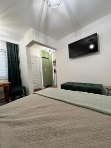 um quarto com uma cama e uma televisão de ecrã plano em Guest House Time Out em Saraievo