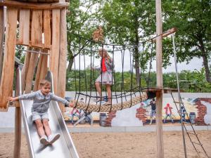 młody chłopiec na huśtawce na placu zabaw w obiekcie TopParken - Recreatiepark Beekbergen w mieście Beekbergen