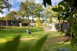 Mężczyzna gra na huśtawce na podwórku w obiekcie TopParken - Recreatiepark Beekbergen w mieście Beekbergen