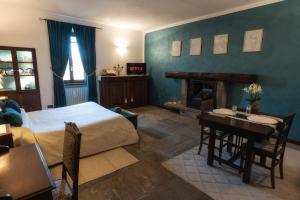 1 dormitorio con cama, mesa y chimenea en B&B Al Castello, en Casale Litta