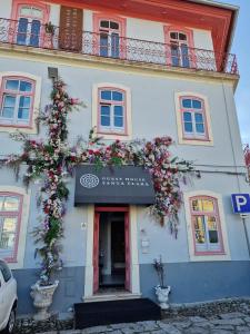 budynek z kwiatami z przodu w obiekcie Guest House Santa Clara w mieście Coimbra