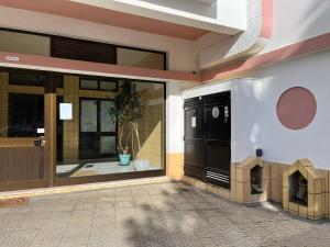 una puerta delantera de un edificio con una casa para perros en Refugio Praia da Rocha, en Portimão