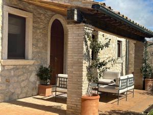 un patio con 2 sillas y una puerta arqueada en Saturnia Country Villas, en Saturnia