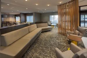 a lobby with a long couch and a bar at SpringHill Suites by Marriott Newark International Airport in Newark