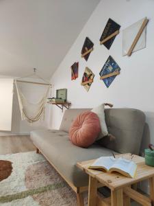 un soggiorno con divano e tavolo con un libro di Wood Essence Apartment - Cozy Balcony a Coimbra