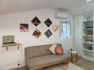 un soggiorno con divano e una parete con aquiloni di Wood Essence Apartment - Cozy Balcony a Coimbra