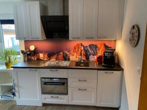 a kitchen with white cabinets and a stove top oven at Spring Inn Apartments in Meiringen