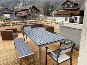 a wooden deck with a table and two chairs at Spring Inn Apartments in Meiringen