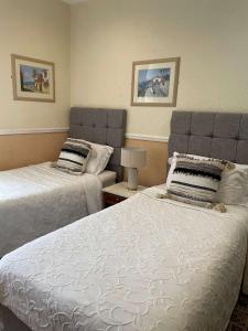 een slaapkamer met 2 bedden en een bank bij Montclare in Llandudno