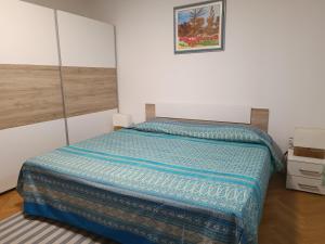 a bedroom with a bed with a blue comforter at Apartmaji Ri-100 in Portorož