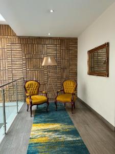 twee stoelen en een tafel in een kamer met een tapijt bij Hotel Real Maestranza in Guadalajara