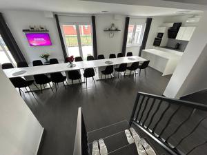 une salle à manger avec une grande table blanche et des chaises dans l'établissement Laura Apartmanház, à Mórahalom