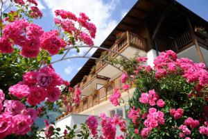 un edificio con fiori rosa di fronte di Feldhof Schenna a Scena